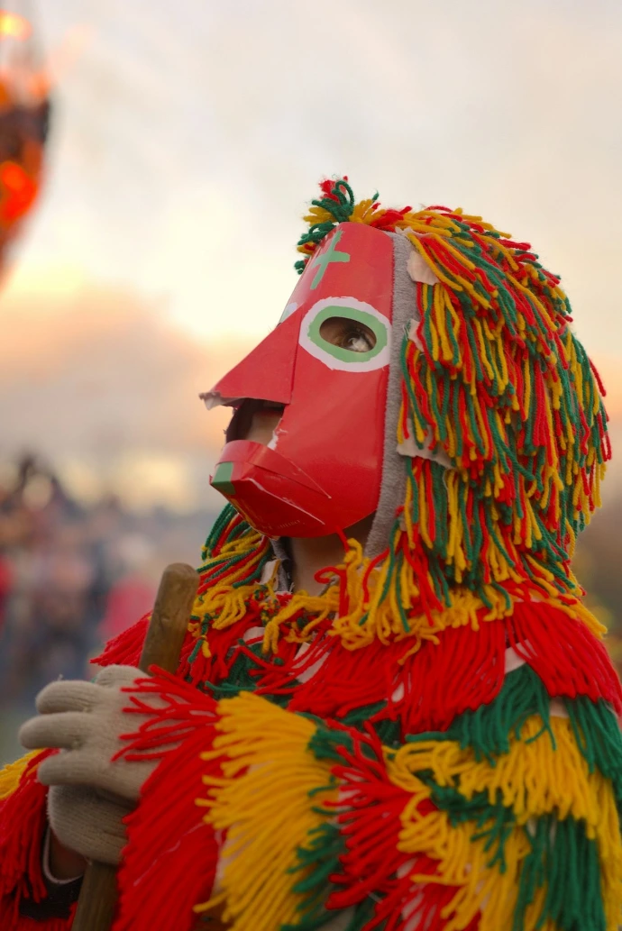 A person wearing a mask and holding a stick
